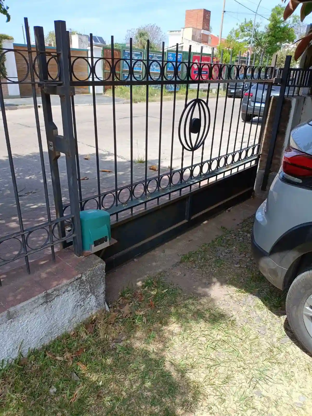 Motor corredizo instalado sobre guía metálica en un acceso vehicular
